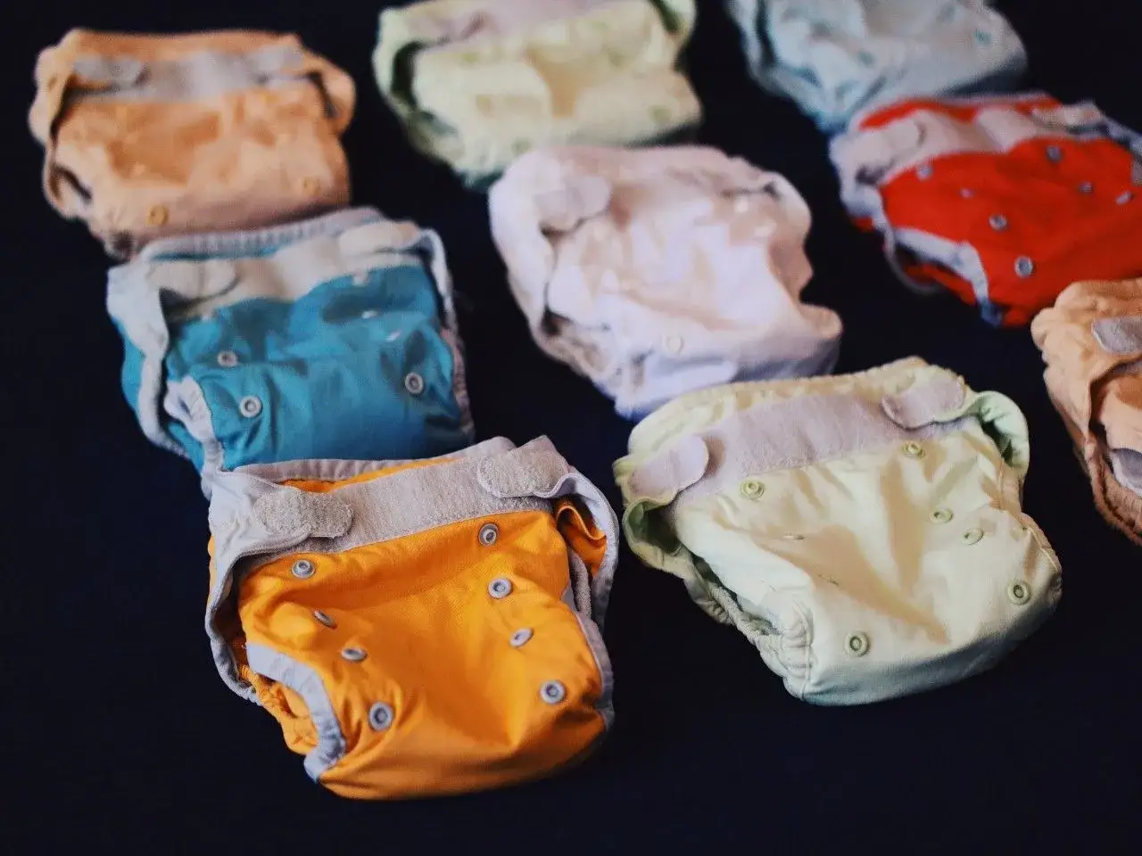 Kolorowe pieluchy wielorazowe, idealne dla noworodka. Różne wzory i kolory, które pomogą wybrać najlepsze pieluchy dla maluszka.